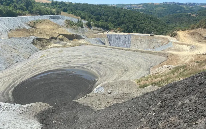 Geomembran kaplı dolgu gövdesi ve çamurla dolmaya başlayan depolama rezervuarı